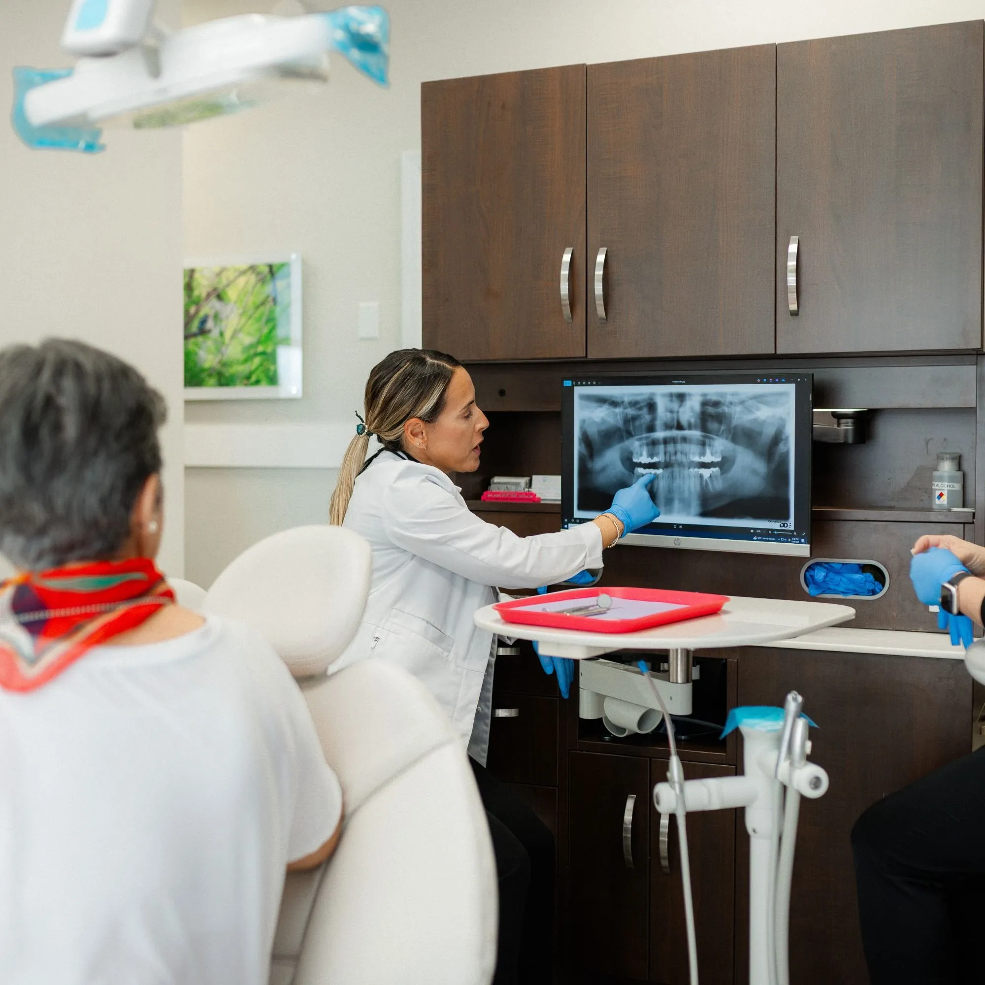 Dentist reviewing a panoramic X-ray on screen with a patient before crown treatment