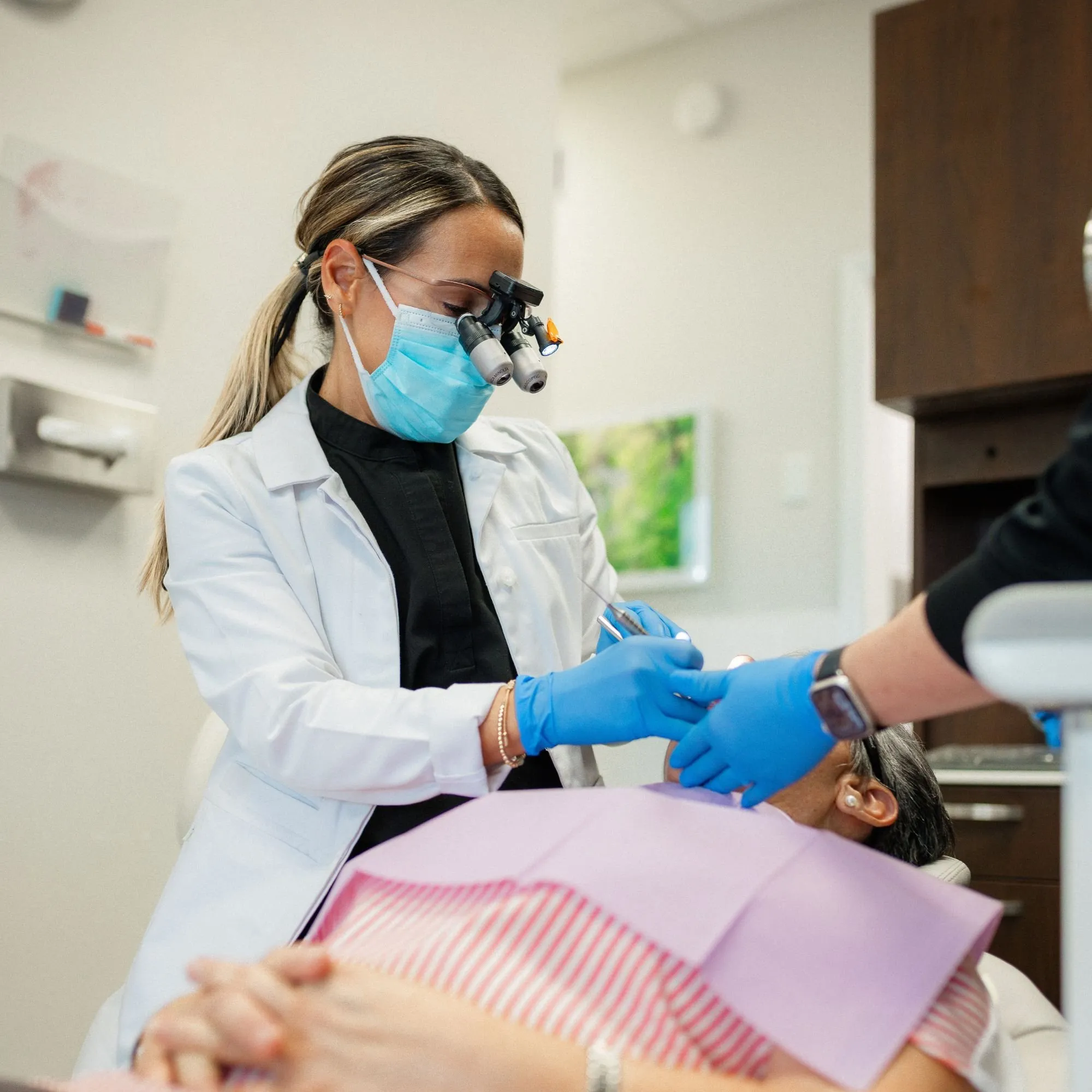 Dentist and assistant performing a gentle tooth extraction chairside