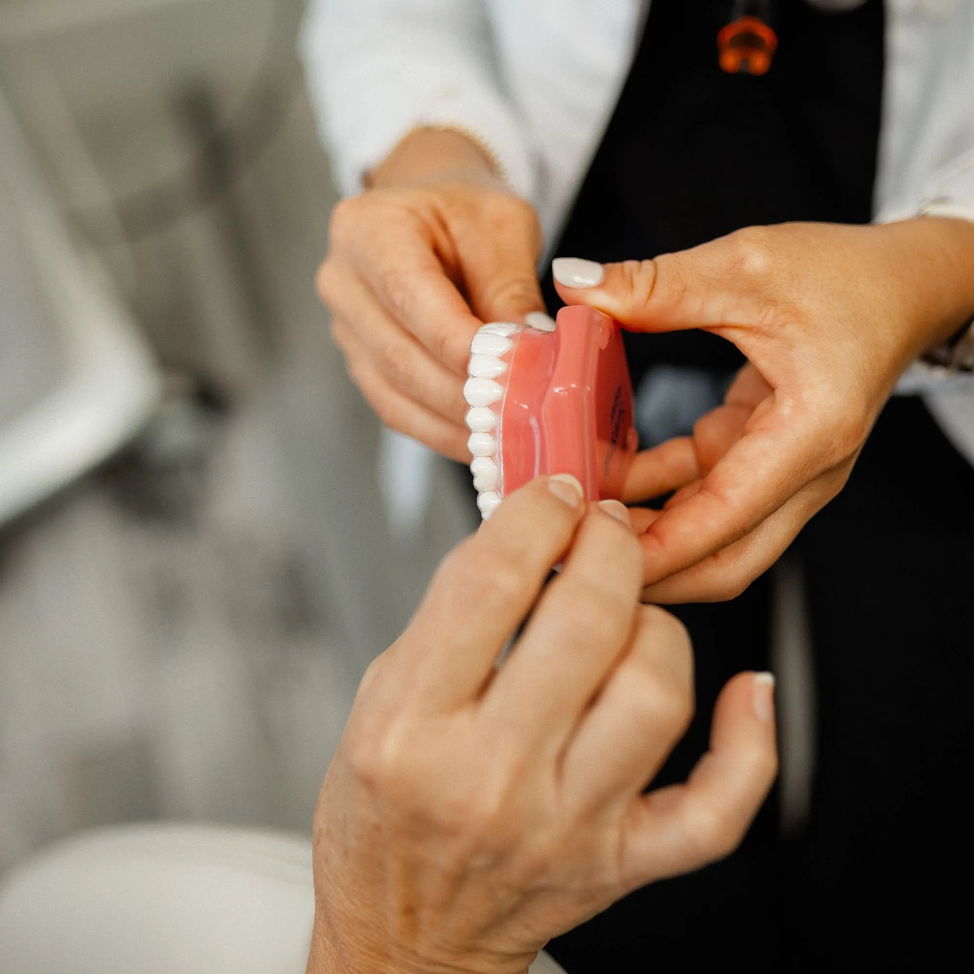 Dentist explaining bite alignment using a model of the upper arch